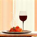 Une table dressée avec un plat final magnifiquement présenté, des verres de vin et une atmosphère conviviale, invitant à la dégustation.